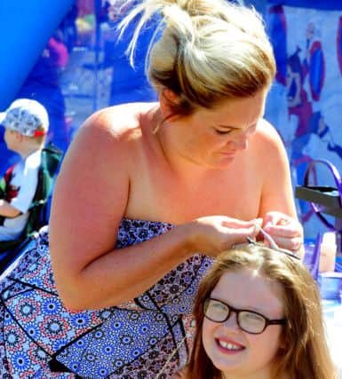 Milliie Evans, eight, having her hair styled by Dulcie Falk