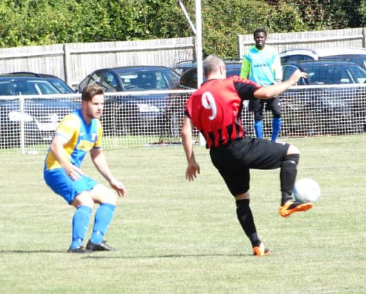Bexhill United full-back Anthony Cooper keeps a close eye on an opponent during last weekend's 7-2 defeat at Oakwood. Picture courtesy Mark Killy