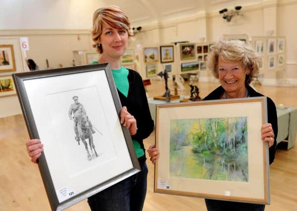 Horsham Artists' annual exhibition. Jennifer White and her "World War I Lancer" in pencil and Jo Hudson and her "Reflections" in watercolour. SR1519400 Pic Steve Robards SUS-150815-104917001