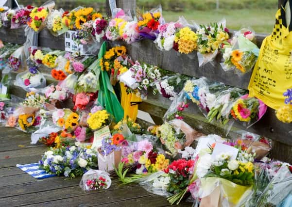People laying flowers in tribute to the people that where killed after a aircraft smashed into cars on busy road on Saturday in front of thousands of horrified spectators at Shoreham airport, Sussex