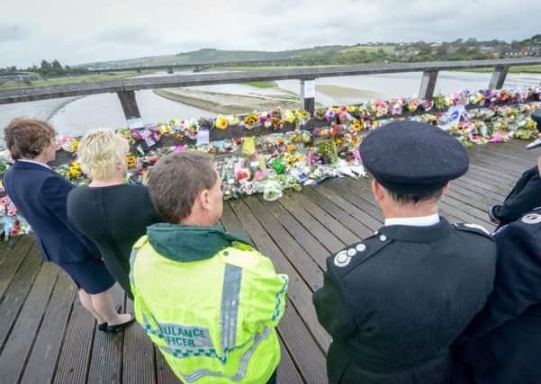 People from Fire, Police, and Ambulance services lay flowers near the site where a aircraft smashed into cars on busy road on Saturday in front of thousands of horrified spectators at Shoreham airport, Sussex SUS-150827-082158001