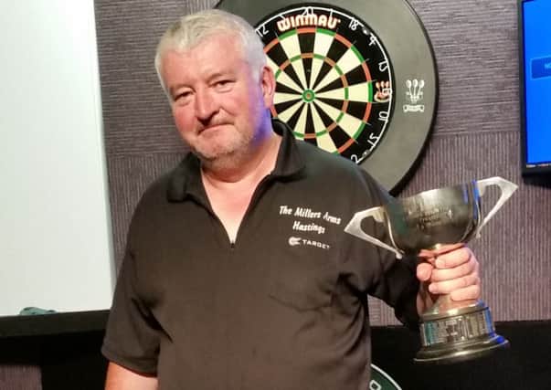 Hastings darts captain Adrian Boyle proudly clutches the trophy