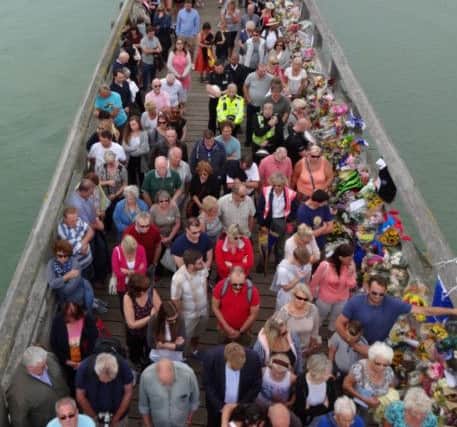 Mourners gather at the Tollbridge in Shoreham to observe a minute's silence