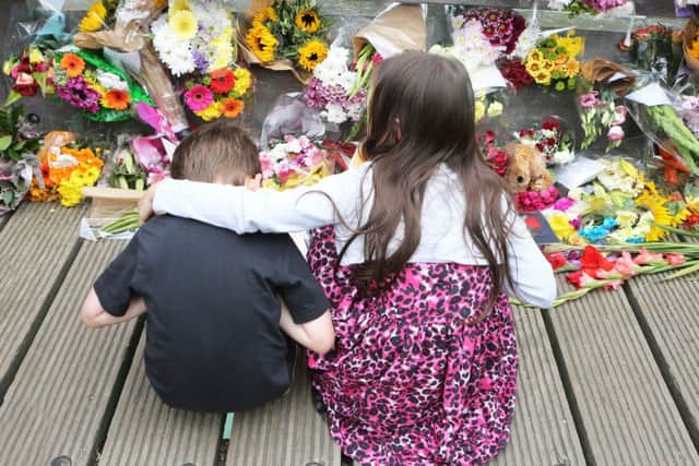 A girl consoles a young boy as mourners remember those who died in the Shoreham Airshow crash