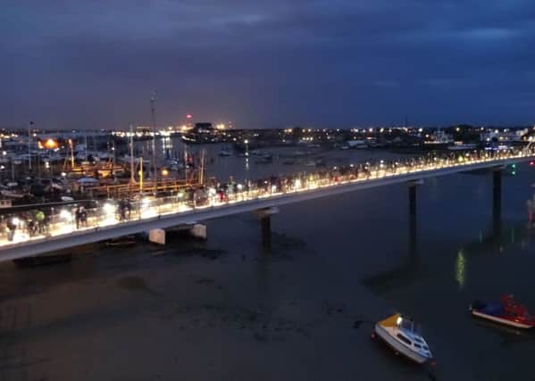 Thousands of people flock to Adur Ferry Bridge to take part in a candlelit vigil remembering those who lost their lives in the airshow crash