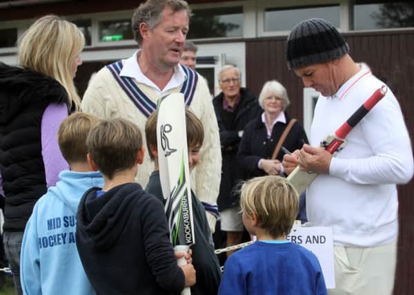 Piers Morgan watches on as Shane Warne signs autographs.  Piers Morgan Legends Xl v Newick CC. Picture by Ron Hill