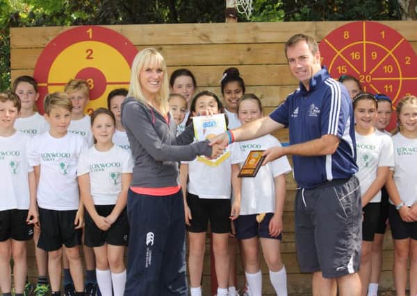 Daisy Price from Loxwood School receives the award from Weald School games organiser Barry Meaney
