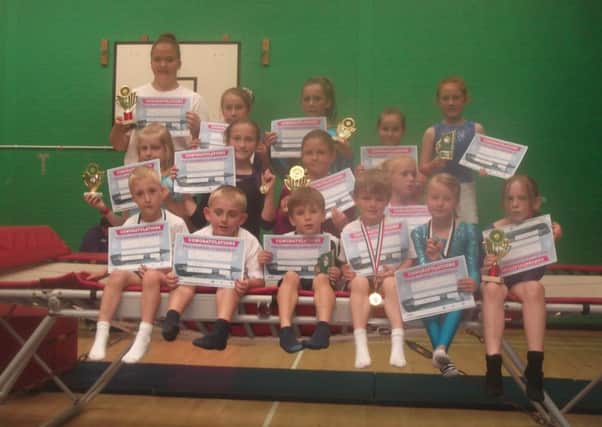 Young trampolinists show off their medals and certificates
