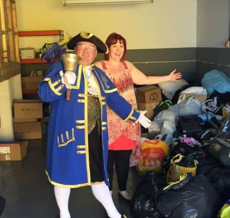 Terri Shanks and Worthing town crier Bob Smytherman at Terri's Littlehampton industrial unit, which she has used for storing donations she will take to refugees in Calais SUS-150922-105106001
