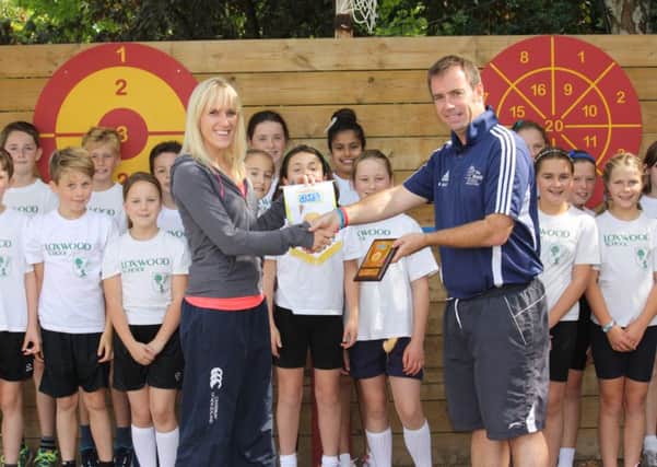 Miss Daisy Price of Loxwood School receiving the Sainsburys School games Gold award from Mr Barry Meaney of The Weald School, Billingshurst. SUS-150922-165048001