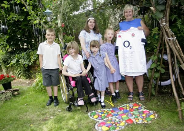 Lesley Dyer, Head Teacher at QEII Silver Jubilee School, holding the signed shirt with students from the school in the area where the Butterfly Remembrance Garden is being created. Picture by Stephen Candy Photography SUS-150928-110945001