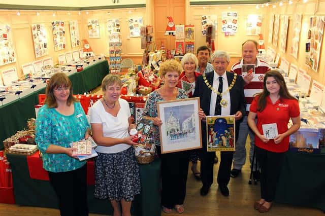 Anna Mills, shop manager, Alison Patrick, Shop manager, Hilary Frame, local artist holding her painting, Judith OSullivan, Regional Organiser, John OSullivan, Volunteer, Peter Budge, The Mayor, Mark Bull, Volunteer for Multiple Sclerosis Trust and Maisie Riddle, Ambassador for Winstons Wish Charity.