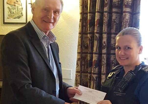 Police community support officer Emma Phillips hands Concorde 1066 chairman Simon Alexander the £500 cheque