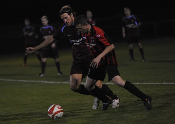Billy Trickett tussles for possession during Little Common's victory at home to Oakwood last night. Picture by Simon Newstead