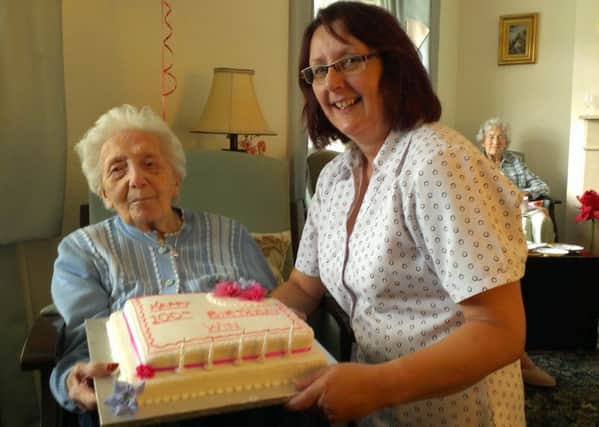 Ashdown Lodge manager Bridget Hart shows Winifred Day her 100th birthday cake