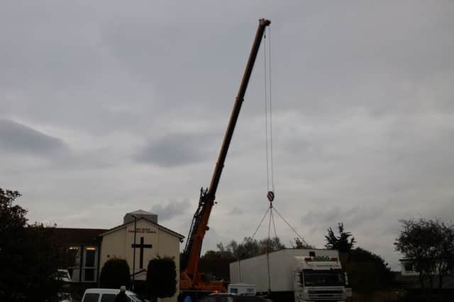 The cabin is lifted over the East Beach Evangelical Church, in Selsey. Picture by Phil Harding