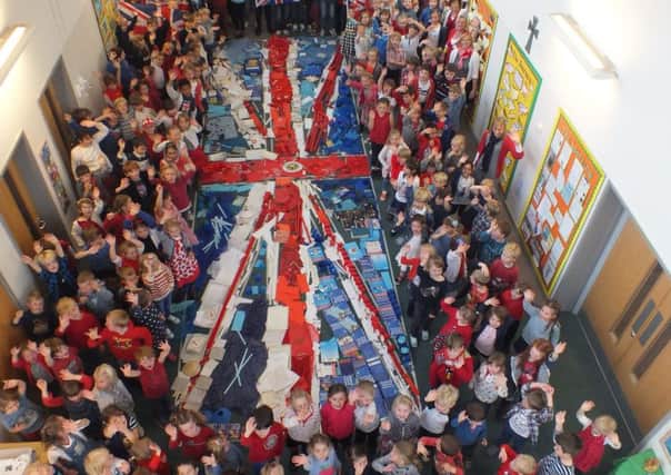 Pupils celebrate the creation of a giant flag at Walberton and Binsted Primary School
