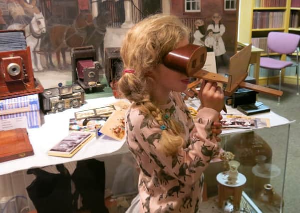 Peering at pictures on a Victorian steroscope at Steyning Museum