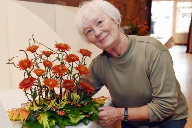 Brenda Gifford with her flower arrangement, A Twist of Autumn LP1502340