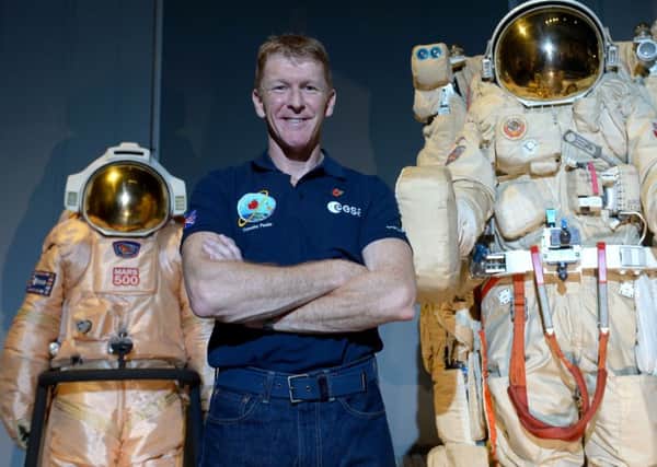 British astronaut Tim Peake poses beside spacesuits as he talks to UK media at the Science Museum, London, before being launched into space Picture by Anthony Devlin/PA Wire