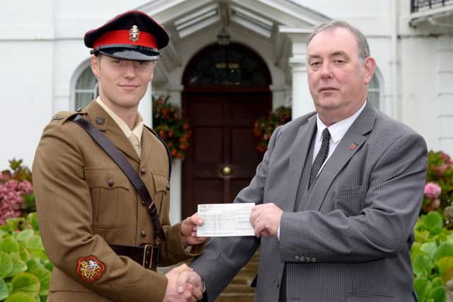 Tom Nugent presents a cheque for £300 from the Cadet Kit Shop to Cadet RSM Max Rogerson