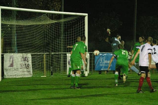 Horsham YMCA's (No.12) Nick Sullivan scores goal number three for the home side