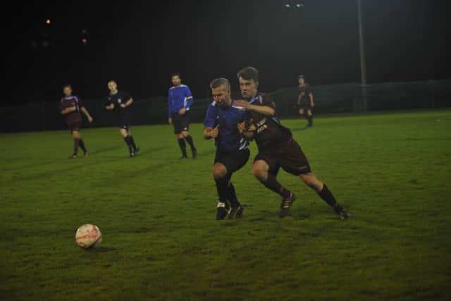 Little Common full-back Byron Nichol tussles with Oakwood's Darren Tidey at the Recreation Ground on Tuesday night. Picture by Simon Newstead (SUS-151111-102226002)