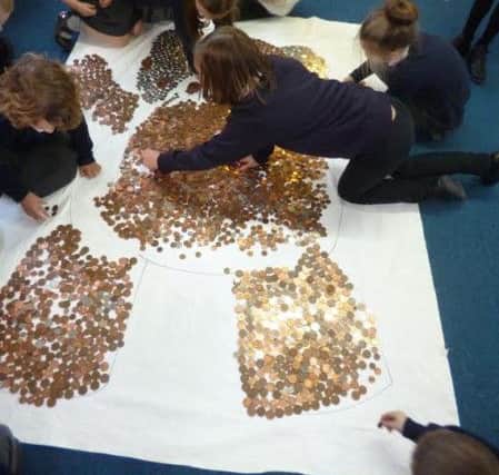 Pupils at Glebe Primary School 'colour in' a giant Pudsey with coins. SUS-151115-140405001