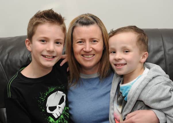 Fletcher Mepham (7) at his home in Burgess Hill with his mum Sarah and his brother Louis (Pic by Jon Rigby) SUS-151117-100437008