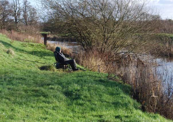 An angler fishes the River Rother