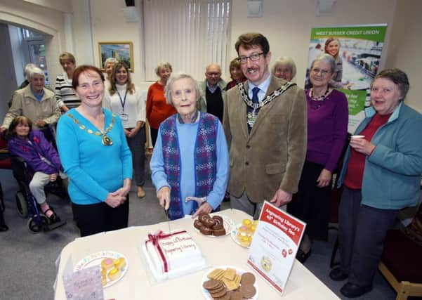 Hilda Norris cuts the cake, accompanied by councillors Susan Francis and Andy Cooper DM15226986a