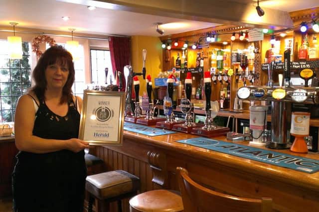 Ye Olde House at Home landlady Elaine Perretta with the framed certificate