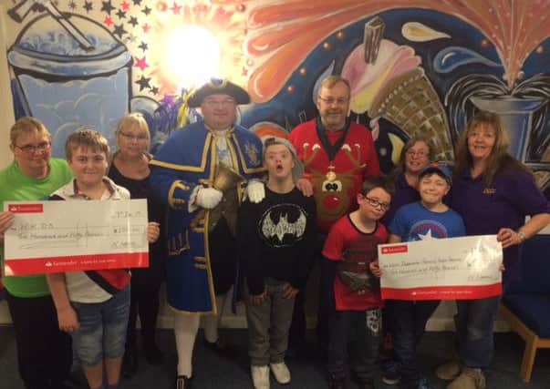 Harvie and Charlie Lomax, who both have ADHD, hand over the cheques to say thank you