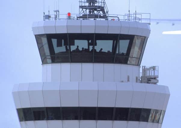 Gatwick Airport control tower with aircraft in flight in background