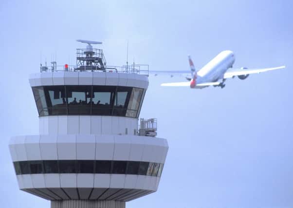 Gatwick Airport control tower with aircraft in flight in background SUS-150705-150051001