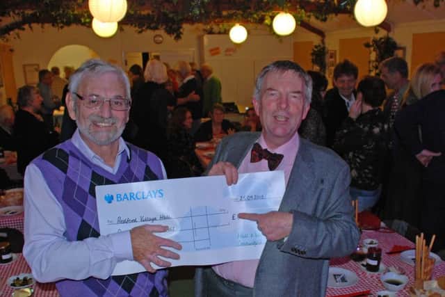 Hall treasurer Roger Lovett, right, receives the cheque from Graham Pooley, Grange trustee