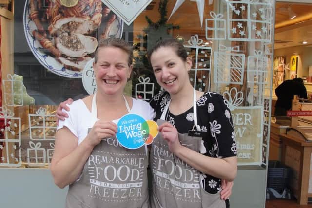 Debbie Bernard (Left) manager of Cook Horsham with her assistant Sam Sanowar (right) receiving their Living Wage Foundation accreditation sticker from Living Wage Horsham (photo submitted). SUS-151222-161716001