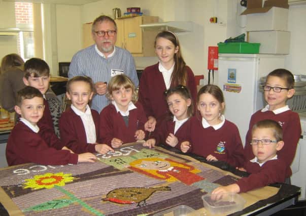 Renowned mosaic artist Paul Siggins with pupils at The Globe Primary Academy, working on the mosaic reflecting the value of resilience