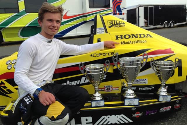 Jordan Cane with his F1600 car and some of his race trophies
