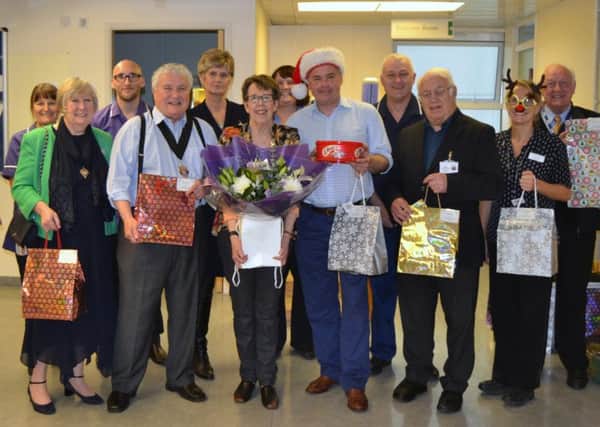 Janet Webber, front, receives a bouquet to thank her for 30 years of buying presents for patients on behalf of the Friends of Worthing Hospital