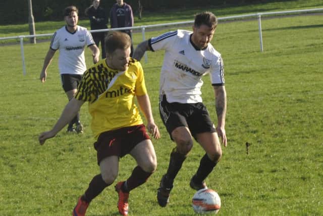 Bexhill United wide player Andy Garman and Little Common winger Dan Estherby tussle for possession. Picture by Simon Newstead (SUS-151228-211856002)