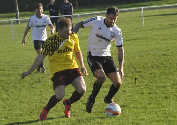 Bexhill United wide player Andy Garman and Little Common winger Dan Estherby tussle for possession. Picture by Simon Newstead (SUS-151228-211856002)