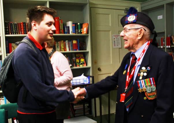 Kane Darley, a year-11 student at Slindon College, shakes hands with war veteran Denis Hosgood