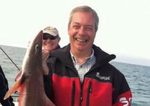 UKIP leader Nigel Farage with a fish he caught off Littlehampton (SUS-150523-134232001)
