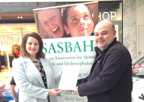Rom Sanglaji, SASBAH chief executive, receives the letter from MP Caroline Ansell during a fundraising day at Eastbourne Arndale Centre