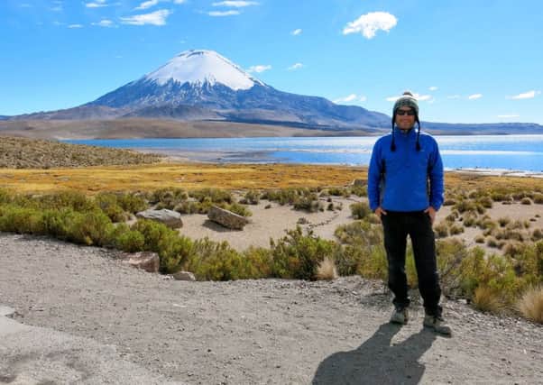 Slinfold man Neil Churchard cycled around the world to raise money for Unicef. Pictured at the foot of a Chilean volcano - picture submitted