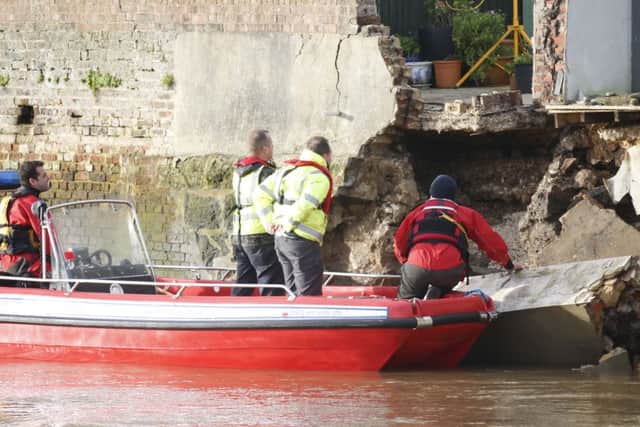 Experts inspect the damage to the river defence wall. Pictures Eddie Mitchell