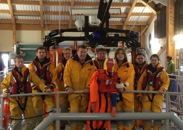 Tim and Catherine Tookey present the beacon to the crew on the lifeboat