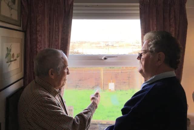 John Prior, 86, looking out of his home at the water on the development, with fellow Selsey resident Alan Redman