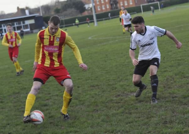 Bexhill United midfielder Aaron Tudor closes down a Lingfield opponent. Picture by Simon Newstead (SUS-160118-102614002)